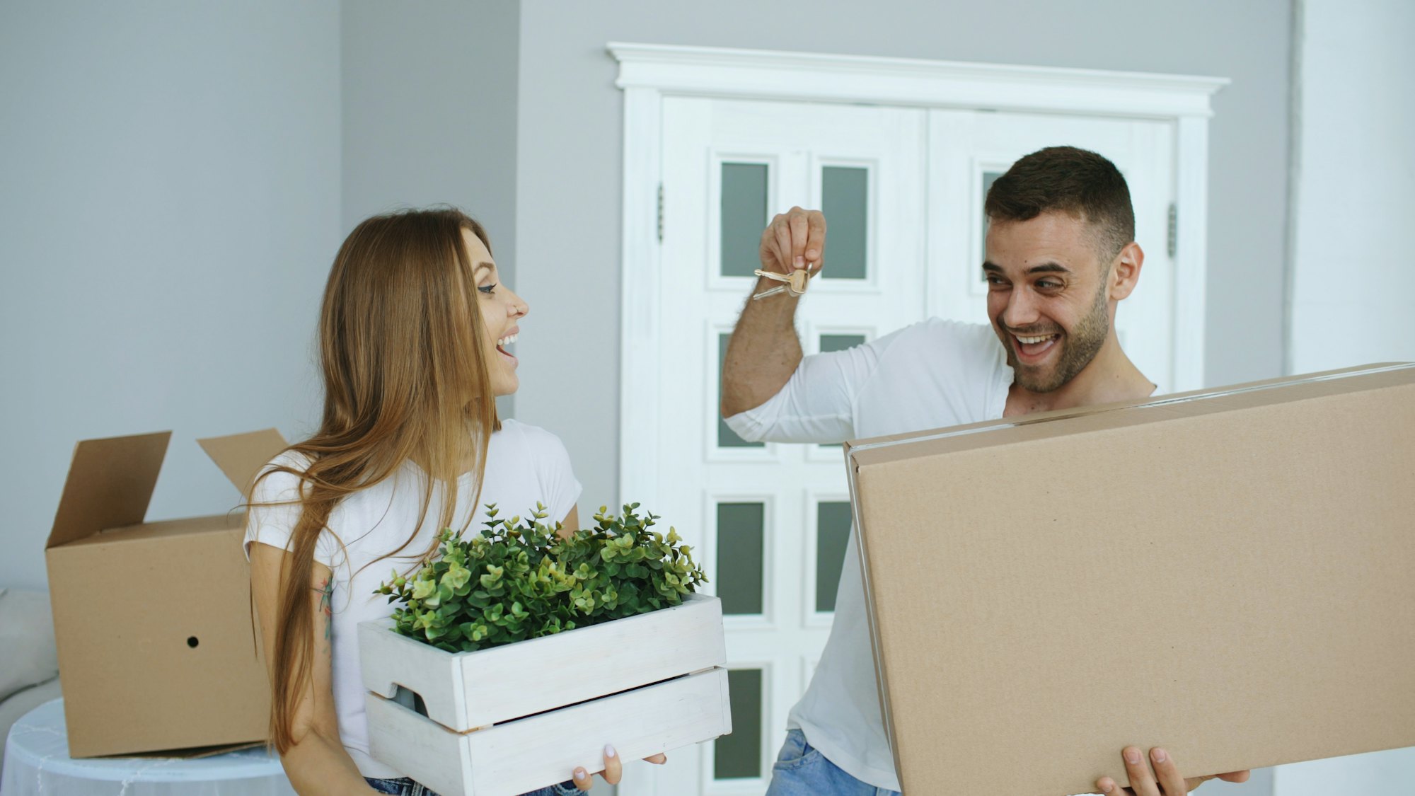 Couple carrying moving boxes into their new home
