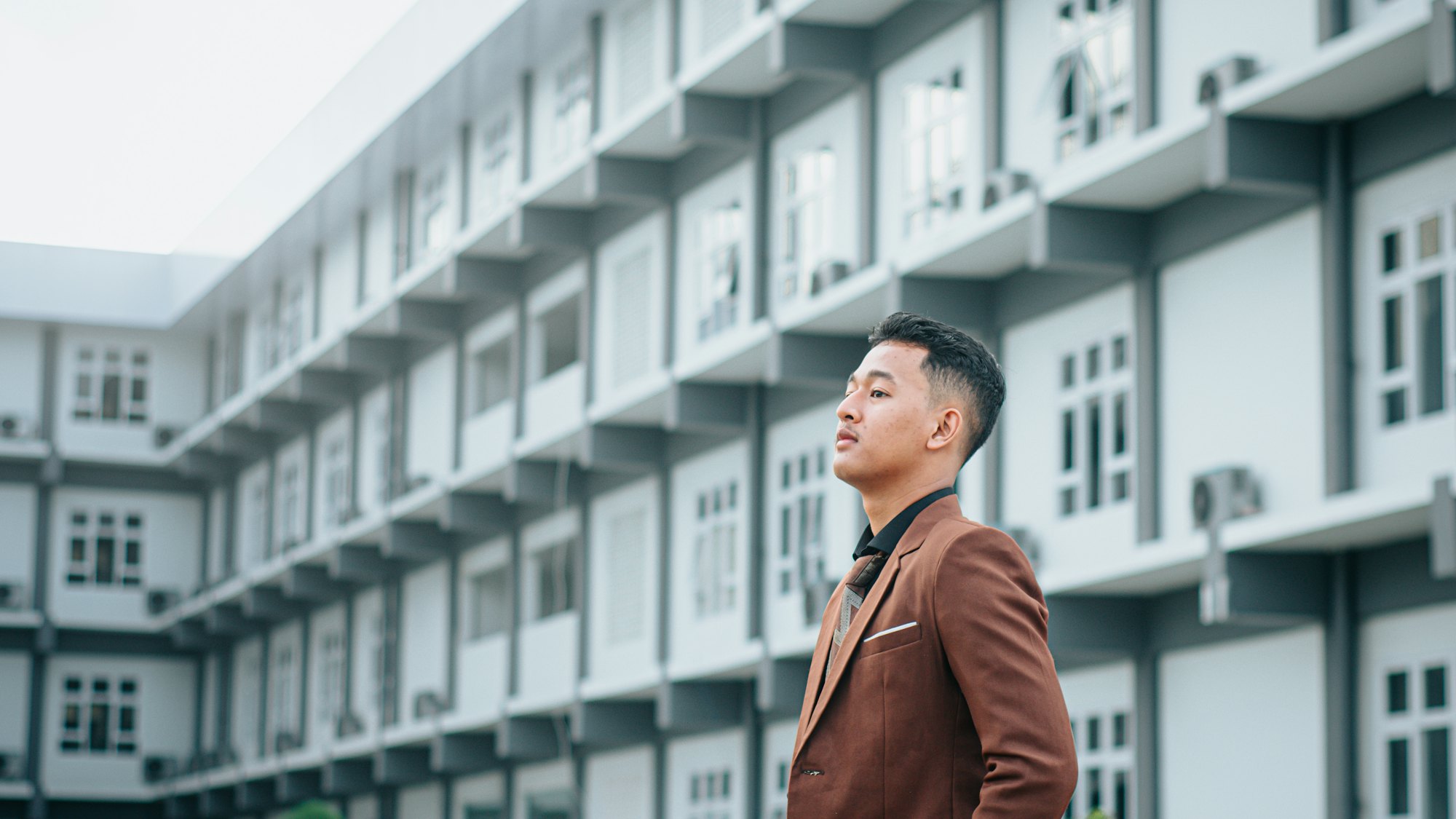 Investor in a suit outside a multi-unit residential building